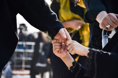Un niño agarra con fuerza la mano de su padre.