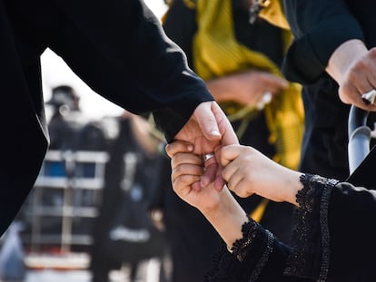 Un niño agarra con fuerza la mano de su padre.
