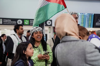 Un miembro de la familia Abed sostiene a un bebé mientras saludan a simpatizantes a su llegada al Aeropuerto Internacional Benito Juárez en Ciudad de México.