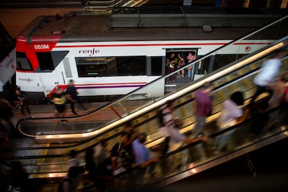 Un tren y varios pasajeros en las instalaciones de Renfe en Atocha.