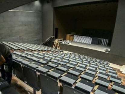 Un operario da los &uacute;ltimos retoques a las butacas del auditorio del centro Garc&iacute;a Lorca en Granada. 