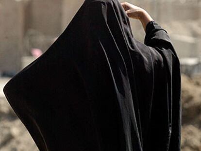 Una mujer, ante una torre de la prisión de Abu Ghraib.