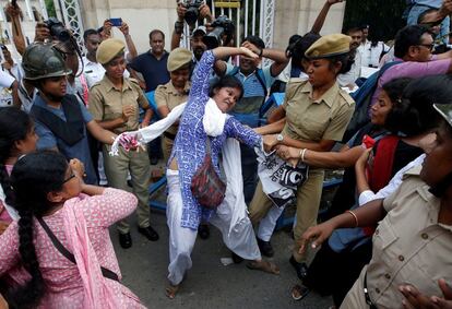 La policía detiene a una manifestante durante una protesta contra la muerte de niños por encefalitis, comúnmente conocida como fiebre cerebral, en Calcuta, India.