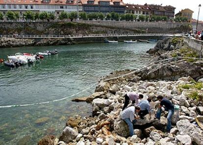 Agentes de la Guardia Civil inspeccionan el lugar del atentado de Llanes.