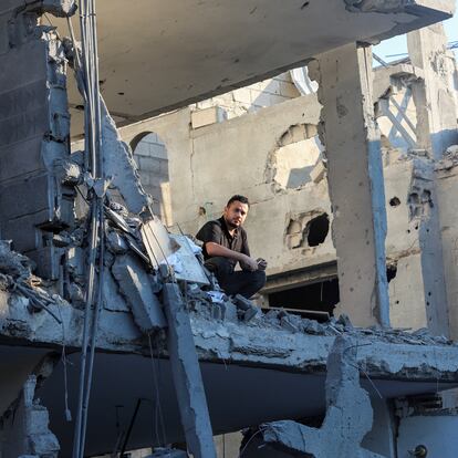 A Palestinian man looks out of a destroyed house at the site of an Israeli strike, amid the Israel-Hamas conflict, in Deir Al-Balah in the central Gaza Strip, August 7, 2024. REUTERS/Ramadan Abed