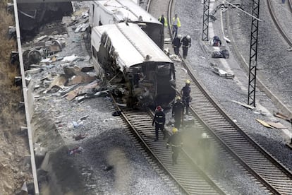 Operarios y bomberos trabajan en el lugar del accidente de tren ocurrido anoche en Santiago de Compostela, en el que han muerto al menos 78 personas.