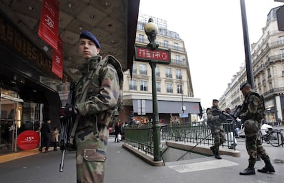 Soldados franceses patrullan en la calle cerca de una tienda en París como parte del más alto nivel del plan de seguridad.