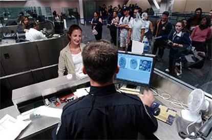 Un agente estadounidense de aduanas toma las huellas dactilares a una pasajera en el aeropuerto de San Francisco.