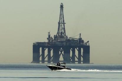 Una lancha pasa frente a una plataforma petrol&iacute;fera. 