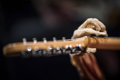 'El guitarrista' sujetando el mástil de una guitarra durante la exposición.