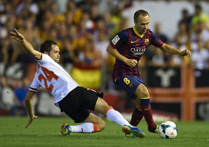 Michel intenta arrebatarle la pelota a Iniesta.