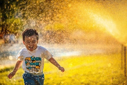 Un niño corre por un parque.