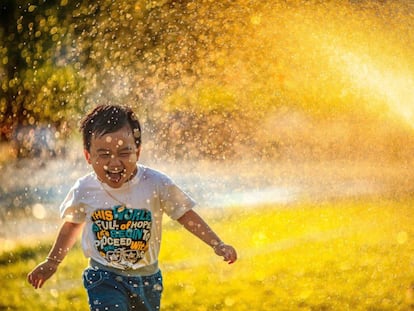 Un niño corre por un parque.