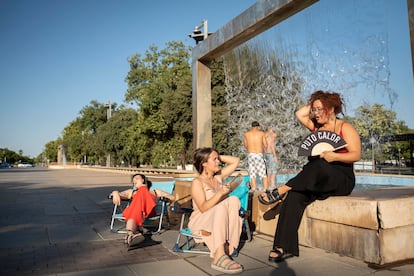 A la derecha, Ana Baena en Córdoba con sus vecinas intentando refrescarse ante la dificultad para acceder a una piscina municipal, el 31 de julio.