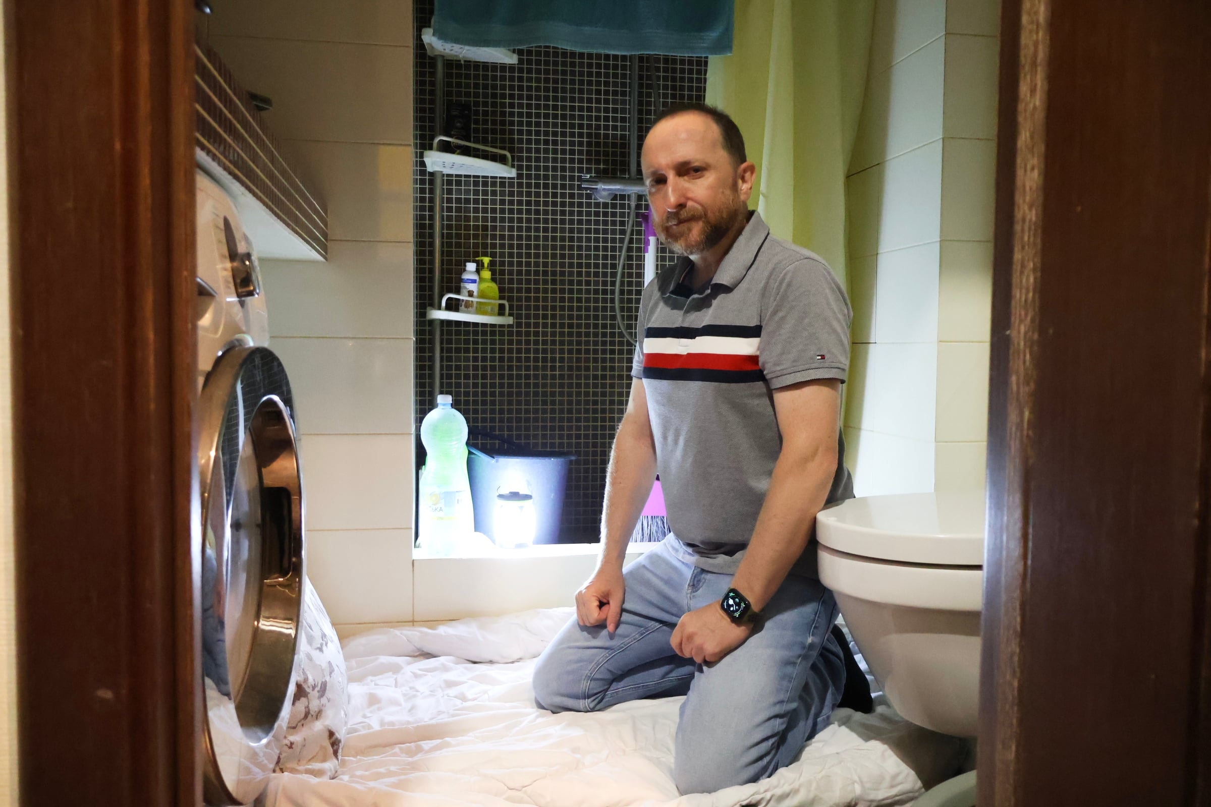 Ángel muestra el espacio en el baño de su apartamento en Kiev donde se refugia durante los bombardeos, el 17 de julio.