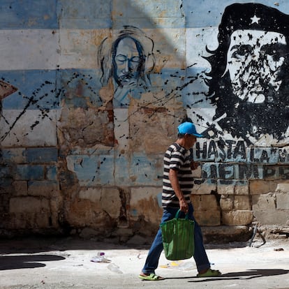 Una persona camina frente a un mural con la imagen de Ernesto 'Che' Guevara este jueves, en una calle de La Habana, Cuba