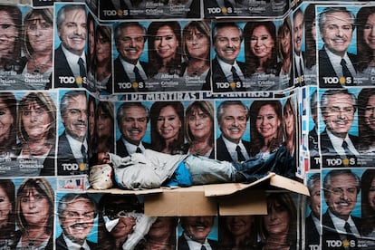 Un hombre sin hogar duerme debajo de los carteles del recién elegido presidente Alberto Fernández y su compañera de fórmula Cristina Fernández de Kirchner en un distrito comercial en Buenos Aires (Argentina), el 28 de octubre.