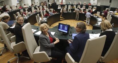 La alcaldesa de Madrid, Manuela Carmena (c), y el concejal socialista, Antonio Miguel Carmona (i), posan hoy al inicio del pleno con 70 menores. 