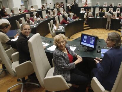 La alcaldesa de Madrid, Manuela Carmena (c), y el concejal socialista, Antonio Miguel Carmona (i), posan hoy al inicio del pleno con 70 menores. 