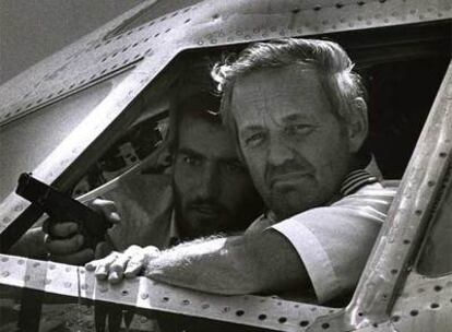 El piloto de la TWA, John Testrake, es tomado por uno de los secuestradores en junio 1985 en Beirut. Imad Mughnieh fue señalado como uno de los resposable de secuestros de aviones, por lo que era uno de los terroristas más buscados por el FBI.