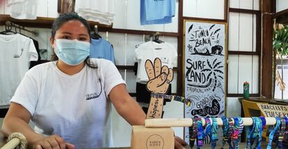 La joven emprendedora Karen Hope exhibe sus diseños surfers en forma de remeras y pulseras ante el incipiente flujo de visitantes que recibió la playa de El Tunco en los últimos días.