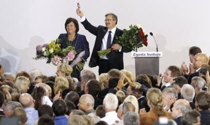 Bronislaw Komorowski y su esposa saludan a sus simpatizantes tras conocer los datos de los sondeos que les daban la victoria en las presidenciales.