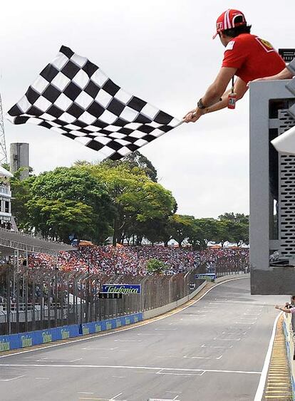 El piloto de Ferrari, que no compite tras su accidente en Hungría, fue el encargado de izar la bandera a cuadros que proclamó a Button campeón del Mundo y a Webber del gran premio