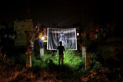 Jóvenes artistas intentan colocar una obra en una zona en construcción mientras participan en el Festival de Arte Popular en Calcuta, India.