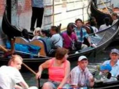 Turistas en góndolas en un canal de Venecia