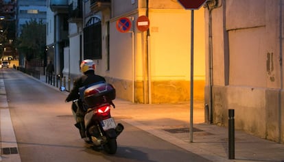 Una motocicleta circula por una calle del barrio de Sants.