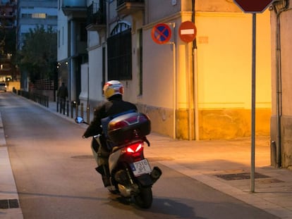 Una moto circula per un carrer del barri de Sants.