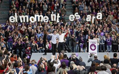 Iglesias (derecha) y Errejón saludan desde el escenario del pabellón de La Fonteta de Valencia, durante en un mitin de Podemos en enero de 2015.
