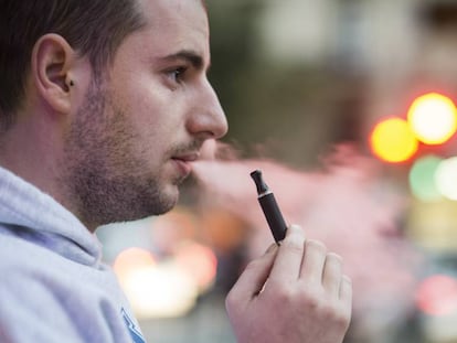 Un home fuma un cigarret electrònic en un carrer de Barcelona