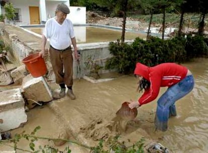 Vecinos de Puente de la Sierra achican el agua de su parcela inundada