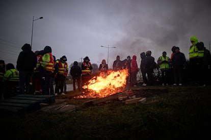 Varios sindicalistas se calientan en una hoguera durante un bloqueo de una carretera cerca de Le Havre, en el noroeste de Francia, este martes.