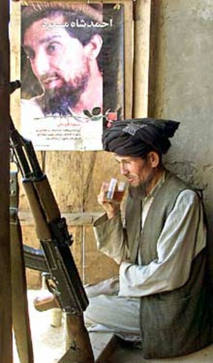 Un guerrero antitalibán, junto a un cartel de Massud, su líder asesinado.