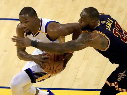 Kevin Durant trata de zafarse de LeBron James.