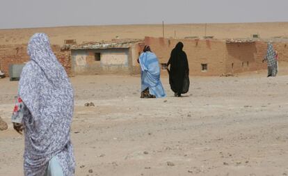 Varias mujeres caminan hacia sus casas de adobe en el campo de refugiados de los saharauis del Polisario en Tinduf ( Argelia).