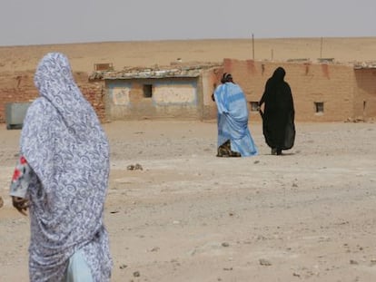 Varias mujeres caminan hacia sus casas de adobe en el campo de refugiados de los saharauis del Polisario en Tinduf ( Argelia).