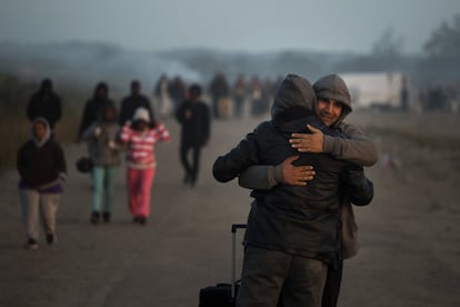 Dos personas se abrazan y despiden antes de abandonar el campamento conocido como 'La Jungla' de Calais. 