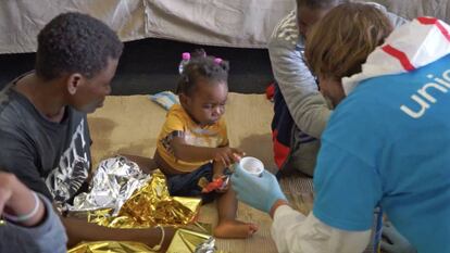 Tras cruzar en lancha el Mediterráneo, un miembro de UNICEF atiende a una niña recién llegada de Libia. / © UNICEF