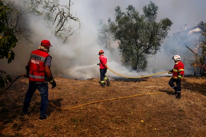 Varios bomberos durante las labores de extinción del incendio en Penalva do Castelo, Portugal, este lunes.