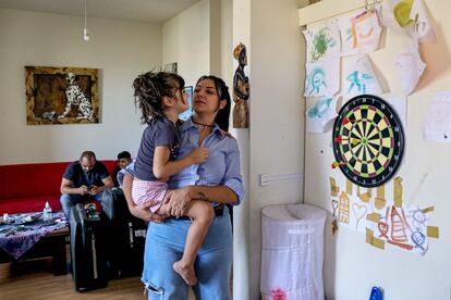 Nanor Abachian sostiene en brazos a su hija Scarlett en su casa de Beirut, el día que están guardando sus pertenencias para emigrar a Chipre.