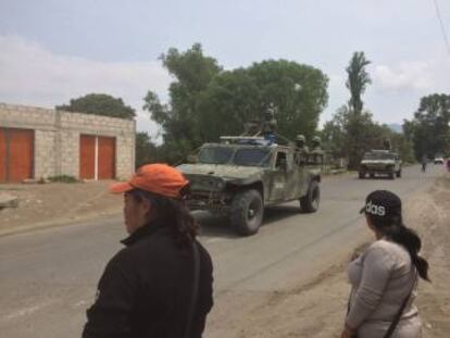 Vecinas de Palmarito ven pasar un convoy militar.