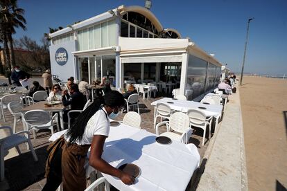 Una camarera prepara una mesa en la terraza en uno de los restaurantes de la playa de la Malvarrosa de Valencia, el pasado lunes.