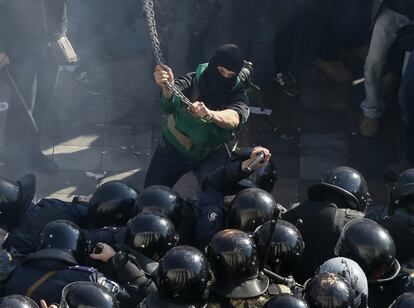 Los manifestantes, en su mayoría jóvenes y muchos de los cuales iban enmascarados y armados con palos o cadenas metálicas, se han congregado frente a la entrada central del Parlamento, en Kiev.