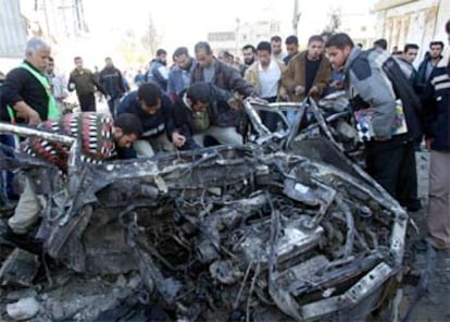 Un grupo de palestinos observa el estado en que quedó el vehículo en el que viajaban los asesinados.