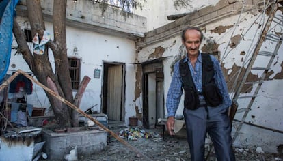 A member of the Kurdish security forces inspects a home reduced to rubble in Qamishli.