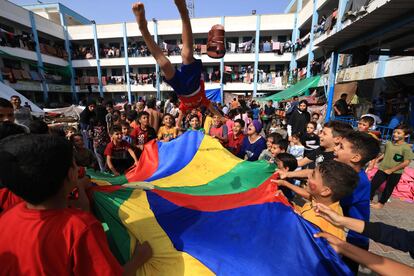 Niños palestinos, que han huido de sus hogares por los ataques israelíes, participan en juegos organizados por trabajadores humanitarios en una escuela administrada por las Naciones Unidas, en Jan Yunis, al sur de la franja de Gaza, este lunes.