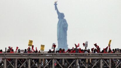 Con la Estatua de la Libertad al fondo, una coalición de grupos de inmigrantes contrarios a la ley de Arizona desfila por el puente de Brooklyn, ayer en Nueva York.